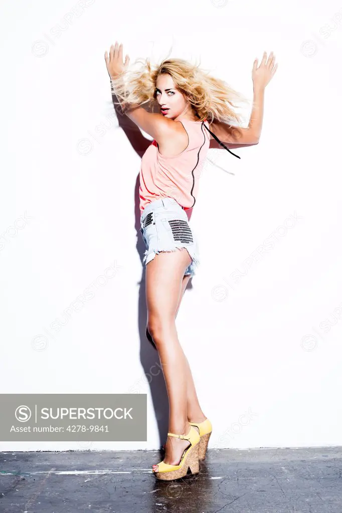 Woman with Hands on Wall Flipping Hair