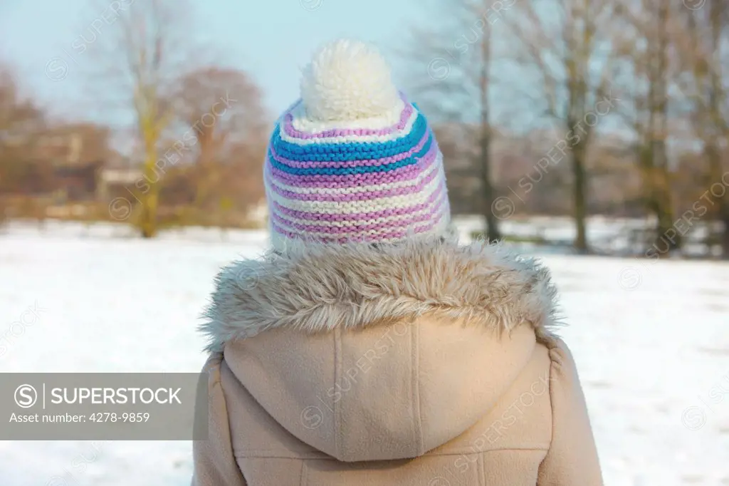 Back View of Girl in a Parka and Wool Hat Outdoors