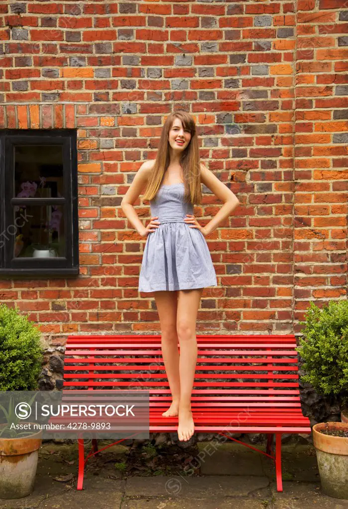 Teenage Girl Standing on Red Bench