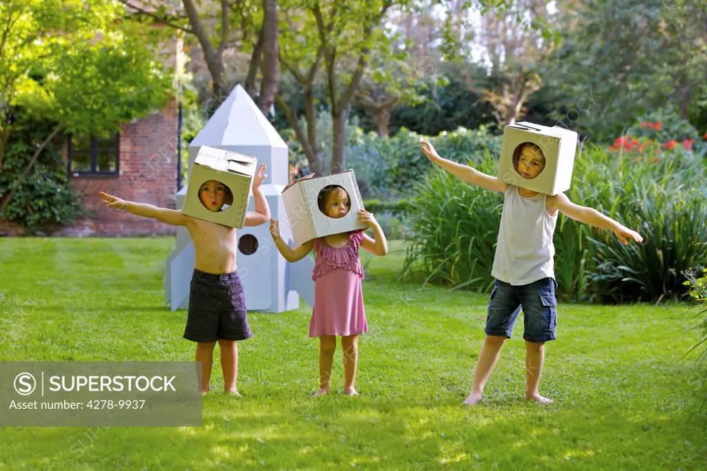 Children Wearing Homemade Cardboard Helmets Playing around Rocket Spacecraft
