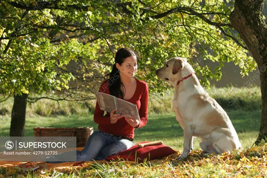 young woman with book and Labrador - under tree