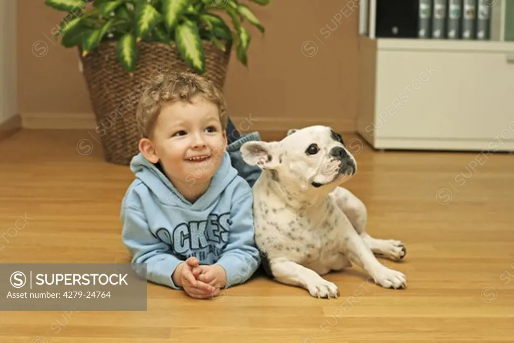 small boy - lying next to young French Bulldog