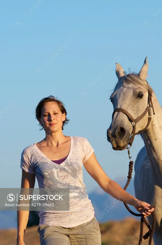 young woman and Arabian horse on meadow