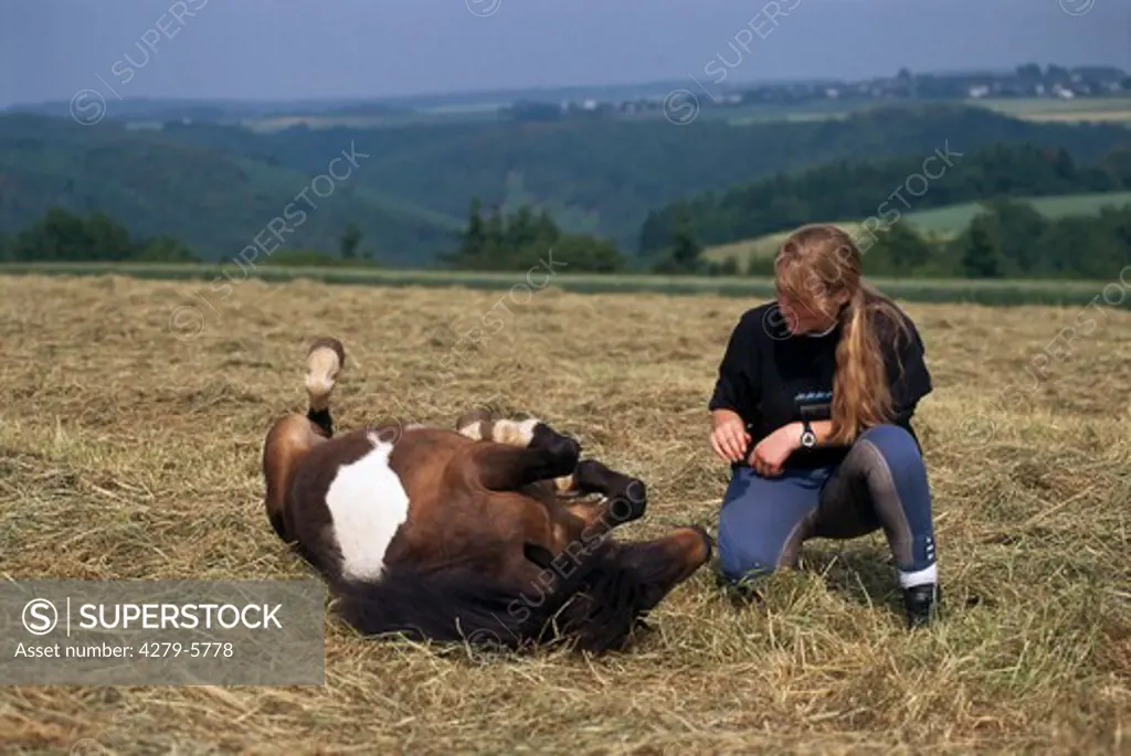 pony rolling around beside a girl