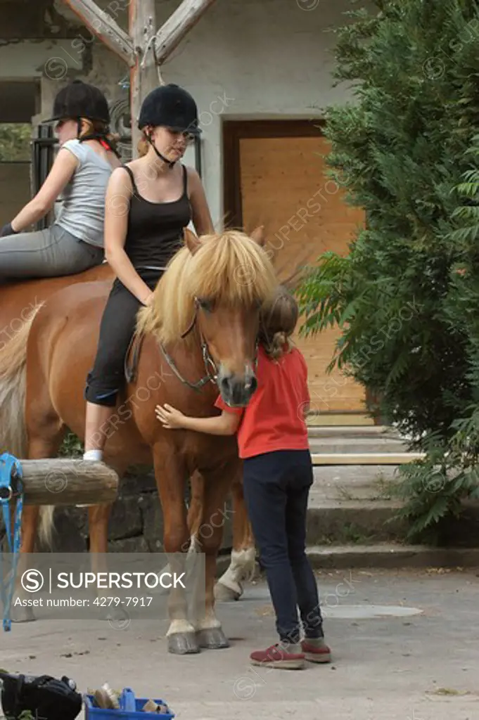 horse with rider - girl standing besides