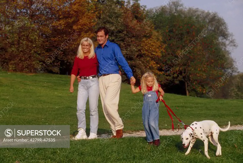 Family with Dalmatian dog - taking a walk