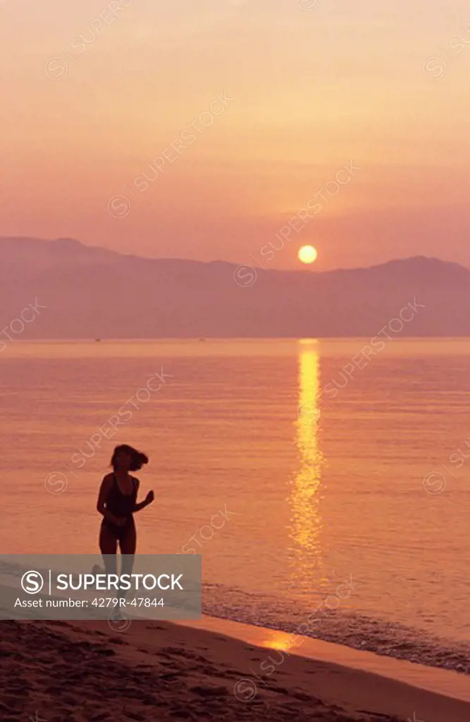 woman - running in water - sunset