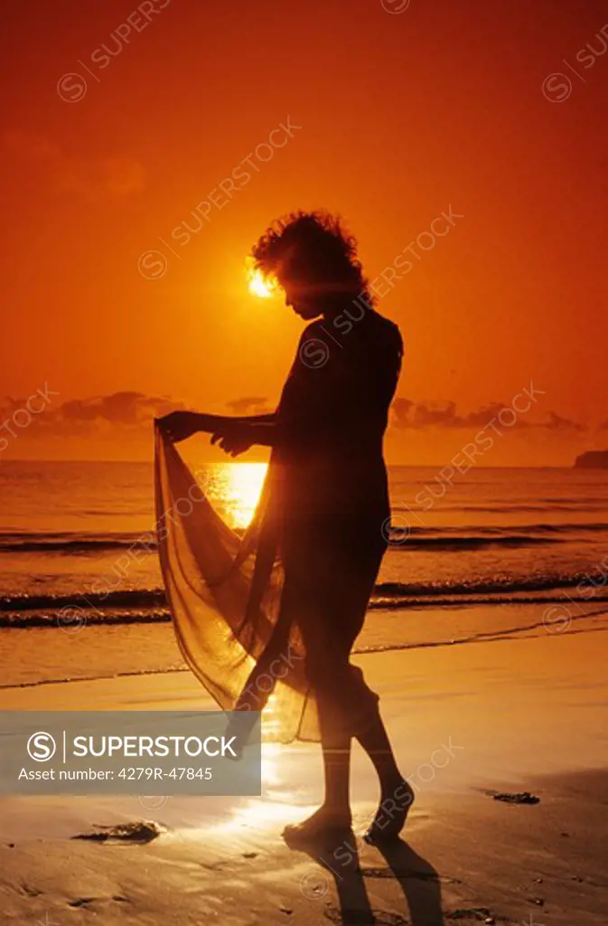 woman - standing at the beach - sunset