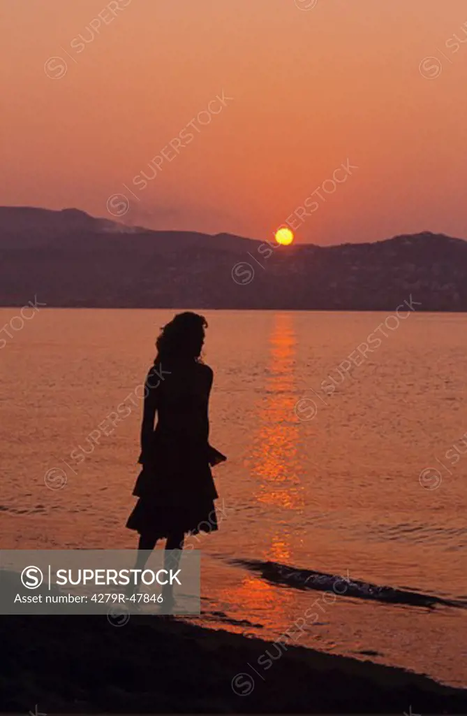 woman - standing in water - sunset