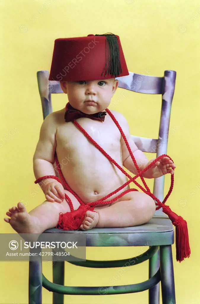 baby with fez - sitting on chair