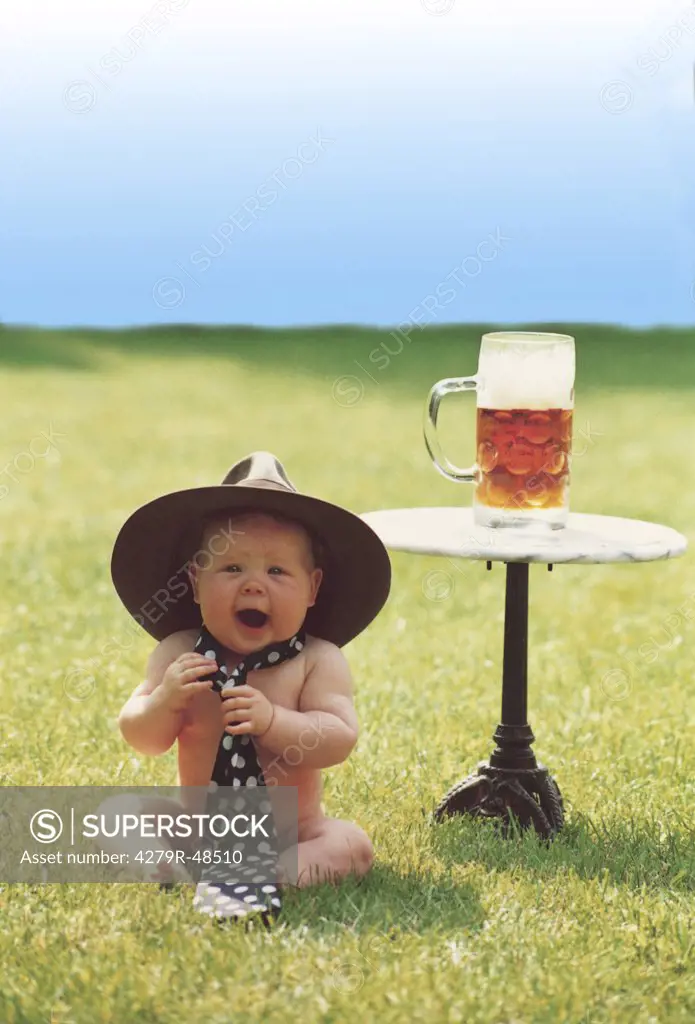 baby with hat and tie - sitting next to table