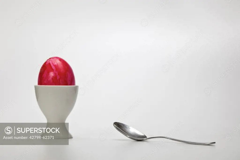Easter egg in an egg cup with a spoon
