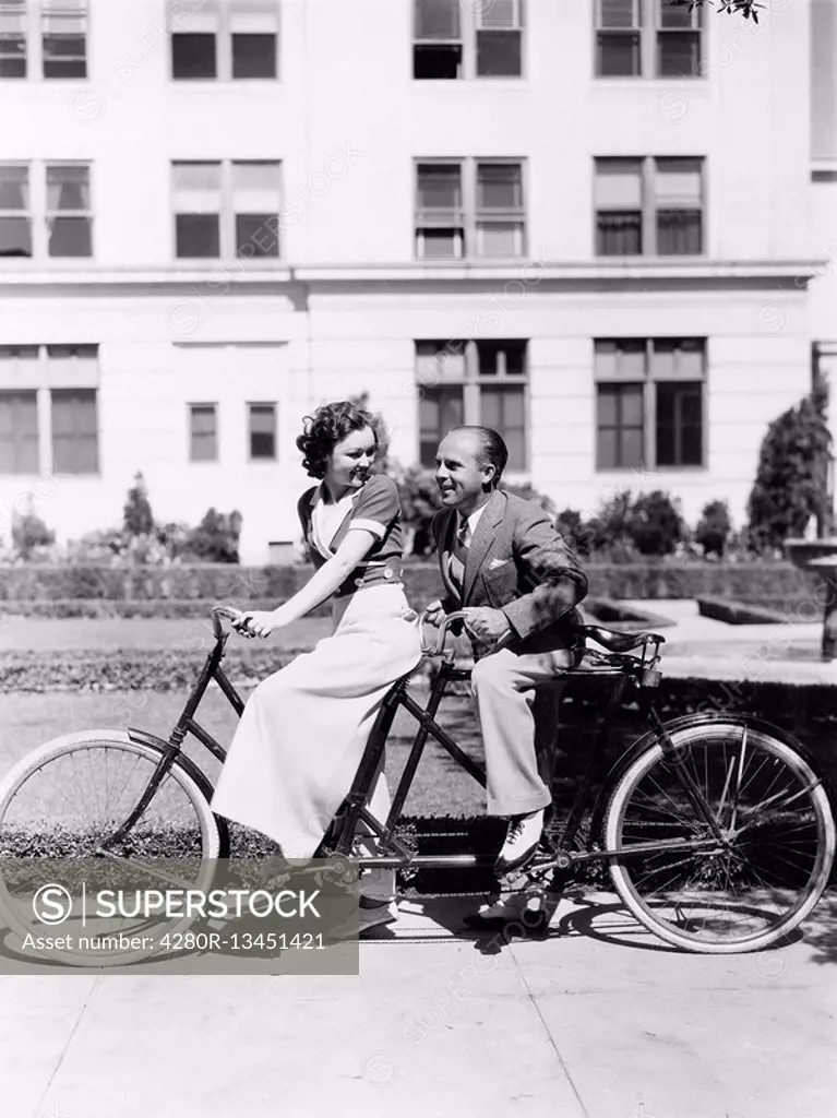 Couple riding tandem bike All persons depicted are not longer living and no estate exists Supplier warranties that there will be no model release issu...