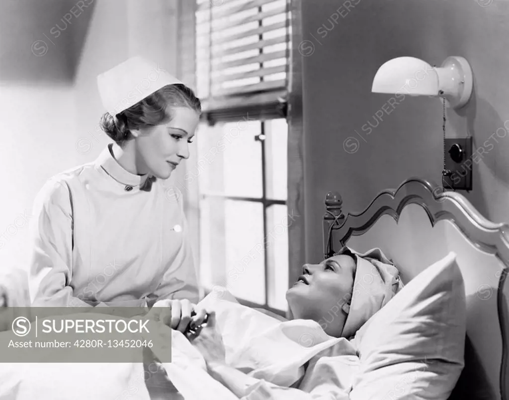 Nurse comforts a patient in a hospital bed, talking to each other All persons depicted are not longer living and no estate exists Supplier warranties ...
