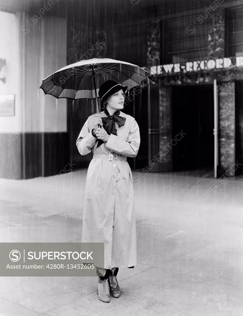 Woman in a raincoat and umbrella All persons depicted are not longer living and no estate exists Supplier warranties that there will be no model relea...