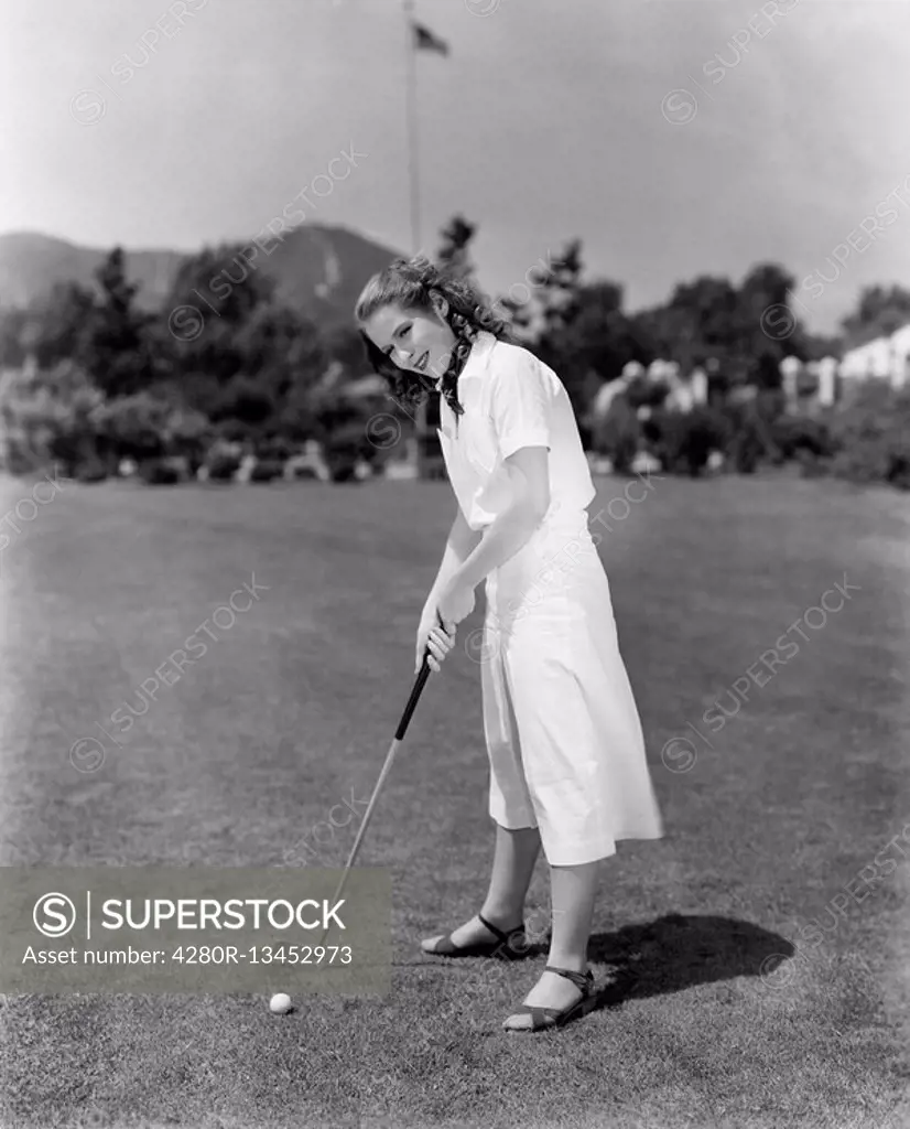 Woman playing golf on a golf course All persons depicted are not longer living and no estate exists Supplier warranties that there will be no model re...