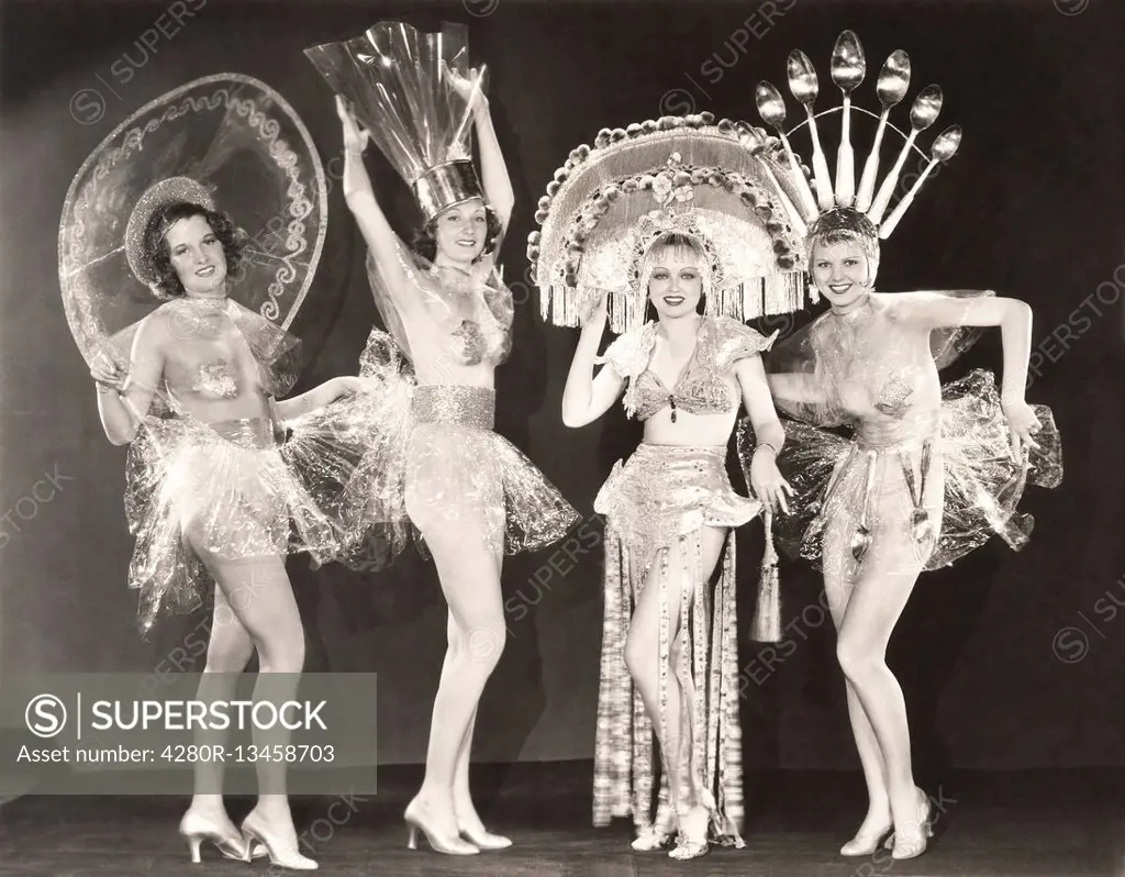 Four women wearing funny hats and costumes