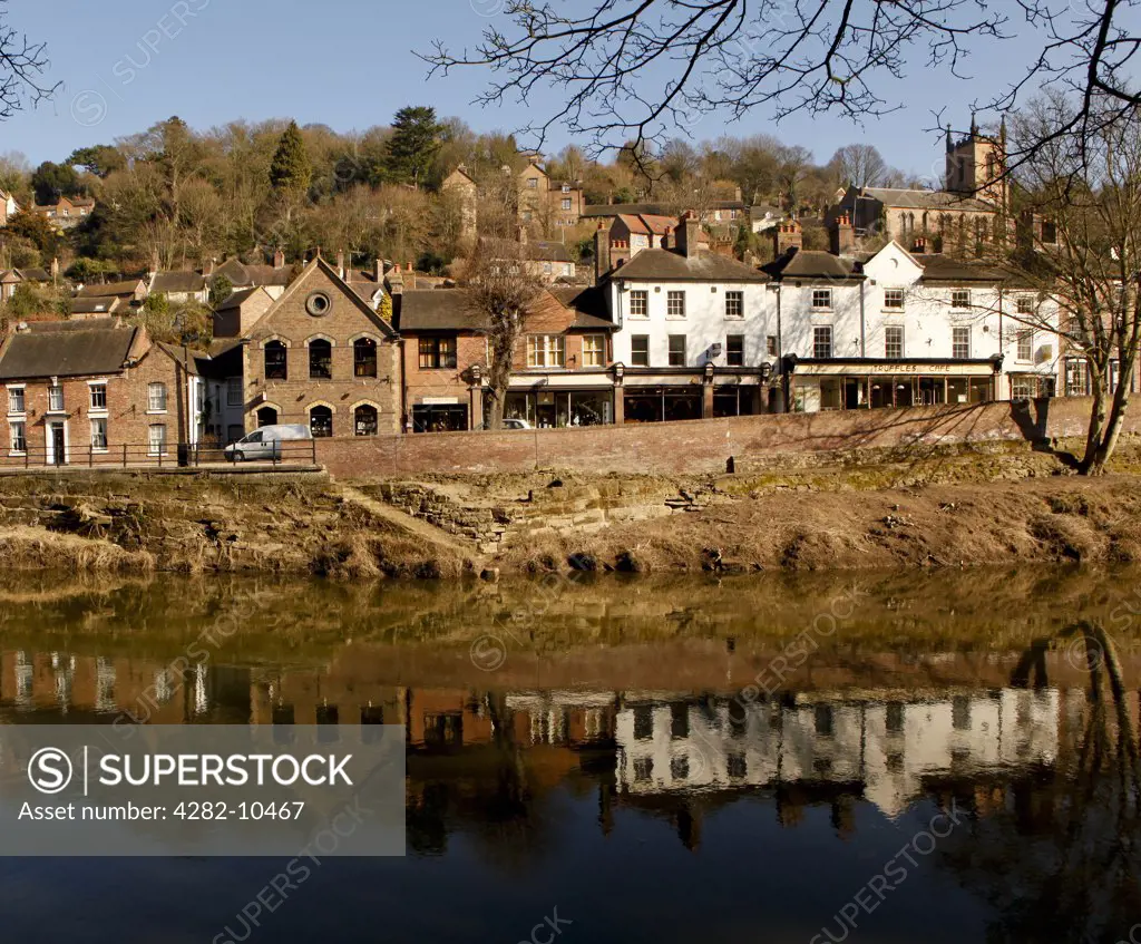 England, Shropshire, Ironbridge. A row of shops and cafes reflected in the River Severn at  Ironbridge, recognised as the birthplace of the Industrial Revolution.