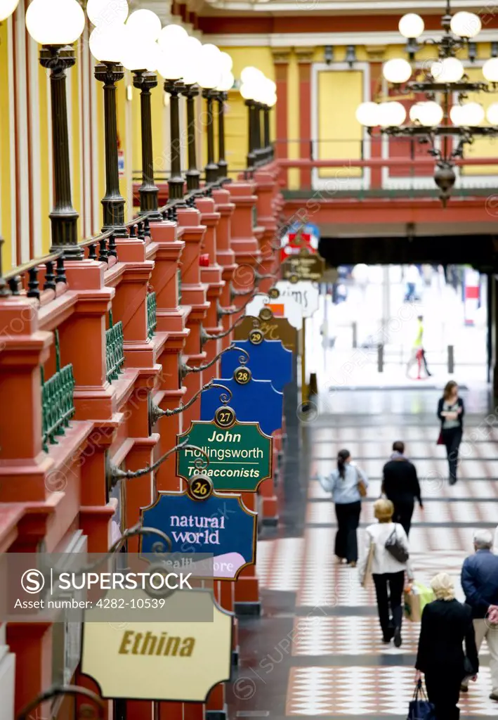 England, West Midlands, Birmingham. A row of signs hanging outside shops in the Great Western Arcade, one of Birmingham's most historic shopping areas.