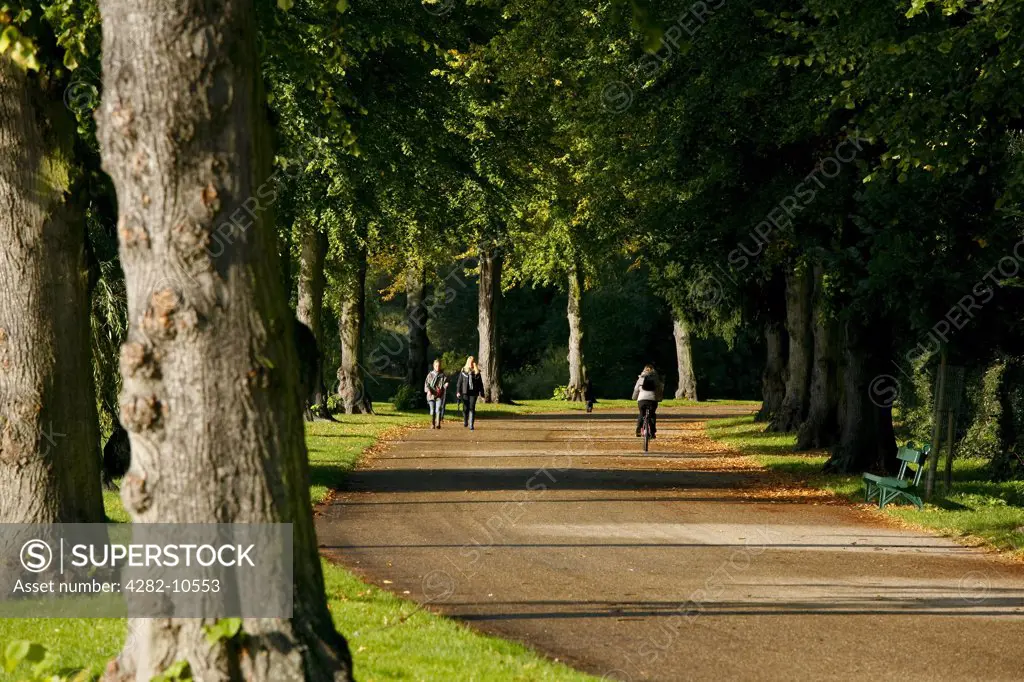 England, Shropshire, Shrewsbury. People walking and cycling on a footpath alongside alongside the River Severn in Shrewsbury.