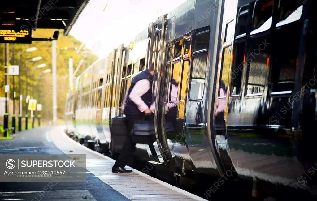 England, West Midlands, Longbridge. A passenger boarding a train at Longbridge train station in the West Midlands.