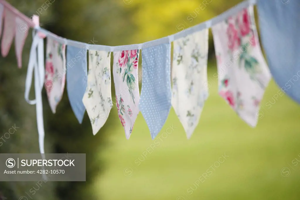 England, West Midlands, Edgbaston. Fabric bunting hanging in a garden.