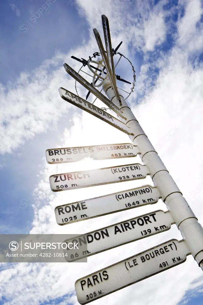 England, West Midlands, Birmingham. Finger post at Birmingham Airport, displaying distances and directions to international destinations.