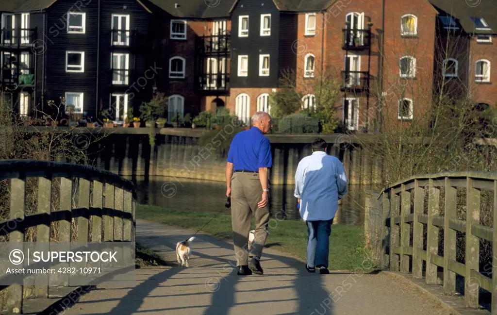 England, Oxfordshire, Sandridge. A couple walking a dog.