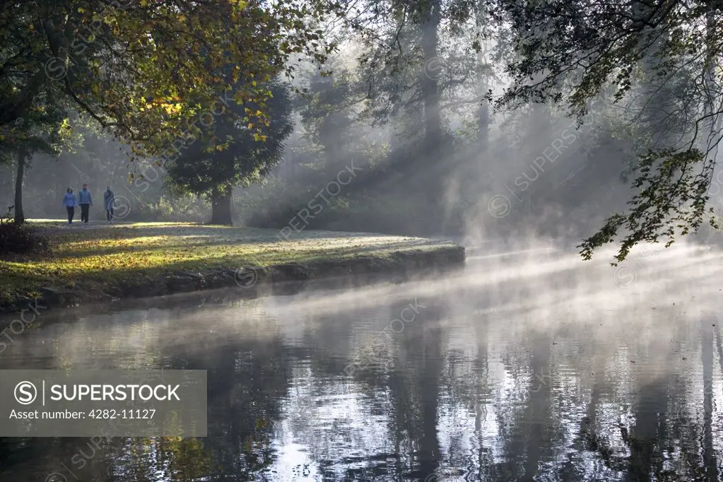 England, Oxfordshire, Oxford. Autumn colour and mists over the Cherwell at Oxford. The Cherwell runs through two secluded areas, Parson's Pleasure and Dame's Delight which used to provide nude bathing facilities for male and female bathers.