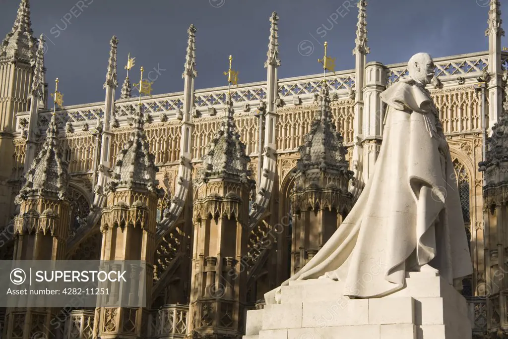 England, London, Westminster. The statue of George V in front of Westminster Abbey with storm clouds brewing.