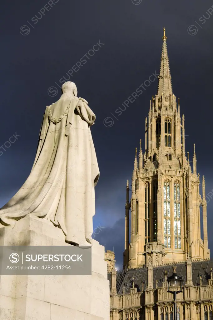 England, London, Westminster. The statue of George V in front of Westminster Abbey with storm clouds brewing.