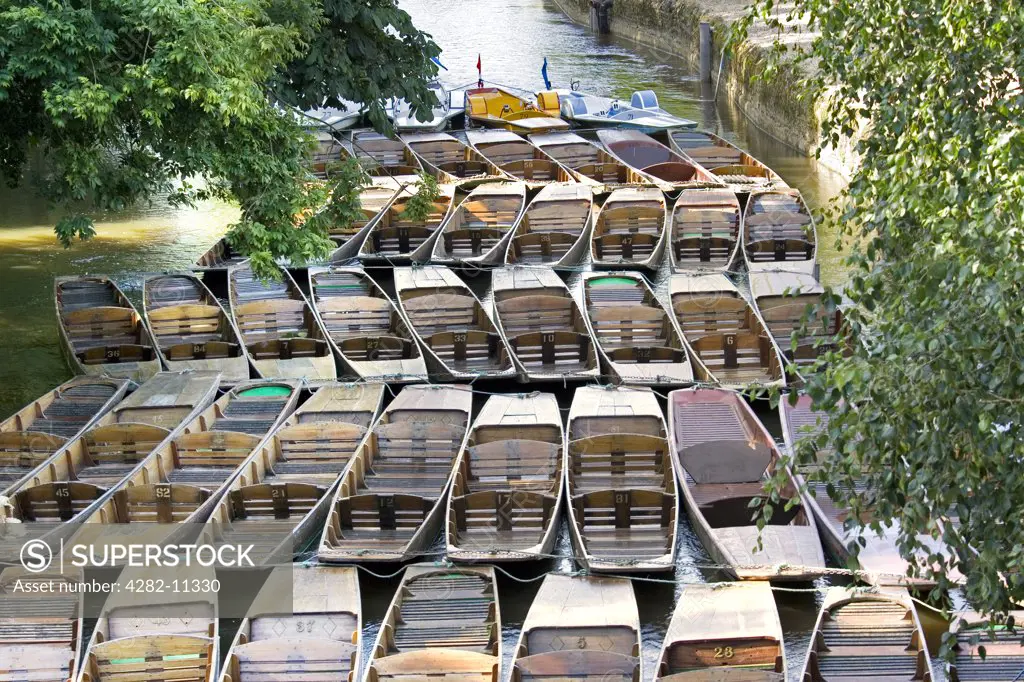 England, Oxfordshire, Oxford. Punts moored on the River Cherwell at Magadalen Bridge.