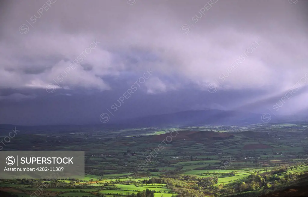 Ireland, County Carlow, Blackstairs Mountains. Brandon Hill in rain cloud with sunbeams.