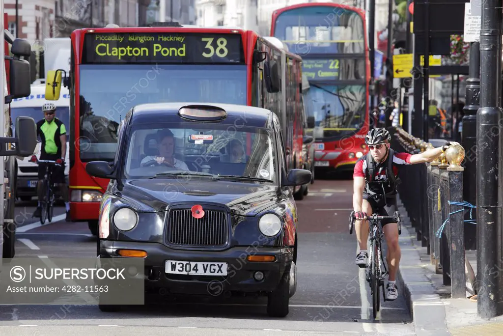 England, London, Piccadilly. Cyclists, busses and taxis waiting at traffic lights in Piccadilly.