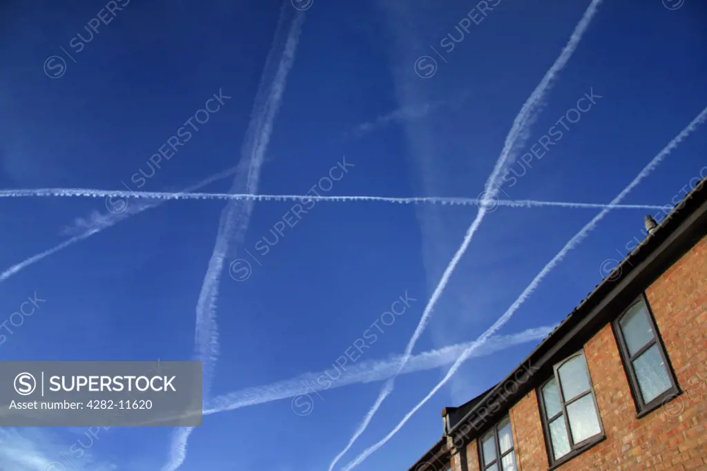 England, Oxfordshire, Radley. Late summer afternoon sky full of contrails.