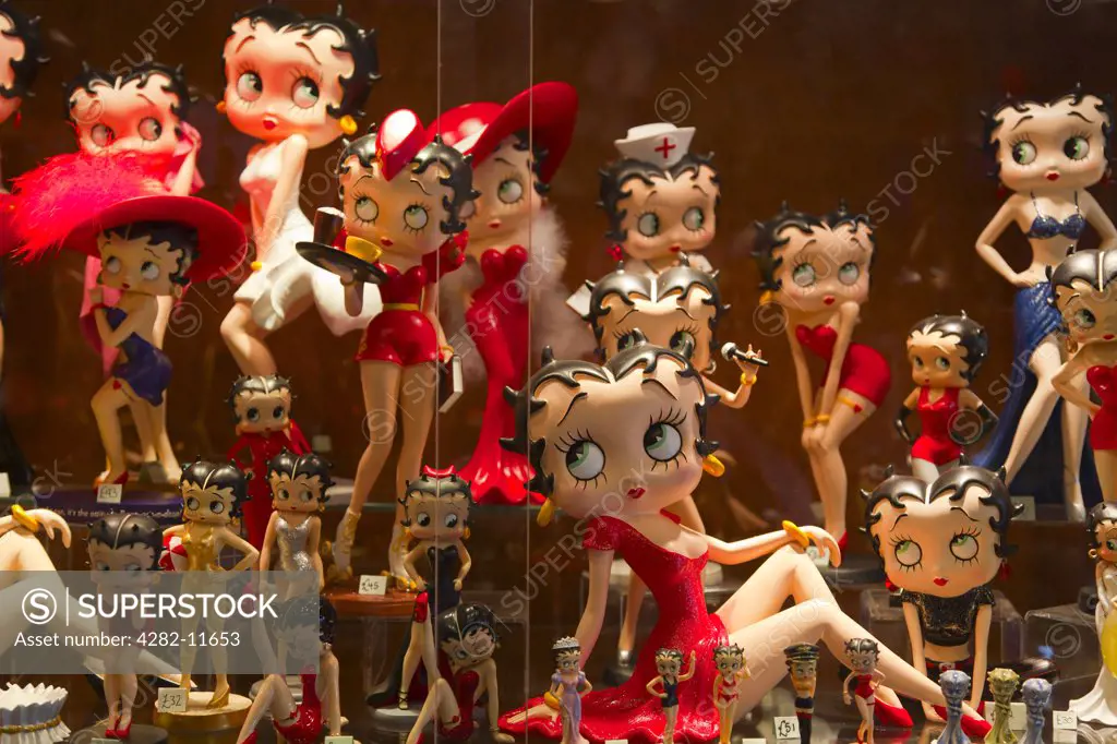 England, Gloucestershire, Bourton-on-the-Water. Betty Boop figurines on display in a shop window.