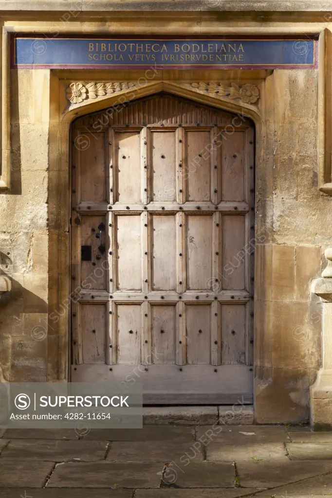 England, Oxfordshire, Oxford. Door to the Bodleian Library, the main research library of the University of Oxford, with Latin inscription above.