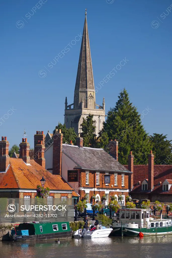 England, Oxfordshire, Abingdon. St Helen's church overlooking boats moored at St Helen's Wharf by The Old Anchor Inn on the River Thames.
