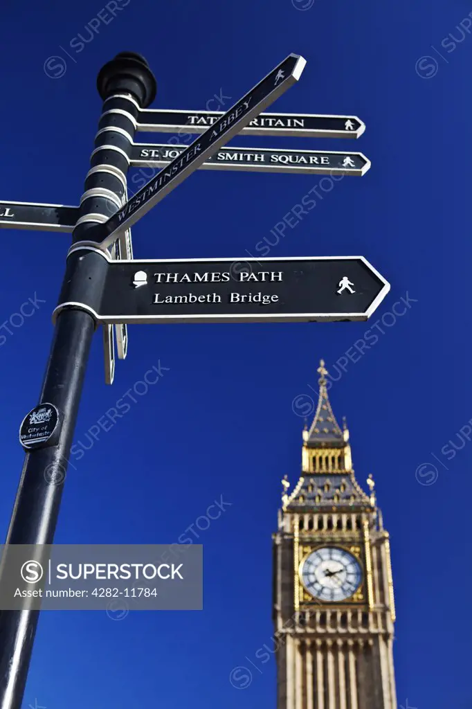 England, London, Westminster. Big Ben towering over a directional signpost pointing the way to the nearby tourist attractions.