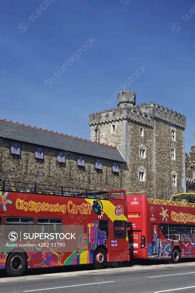 Wales, Cardiff, Cardiff. Open-topped double decker sightseeing tourist buses outside Cardiff Castle.