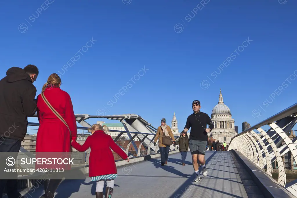 England, London, City of London. People crossing the Millennium Bridge from Bankside on the South side of the River Thames to St. Paul's Cathedral on the north side.