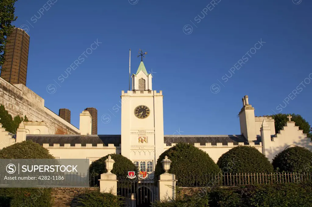 England, London, Greenwich. The clock tower at the riverside entrance to Trinity Hospital. The inscription below the clock reads 'Hospitale Sanctae et Individvae Trinitatis Grenwici' (Hospital of the Holy and Undivided Trinity, Greenwich).