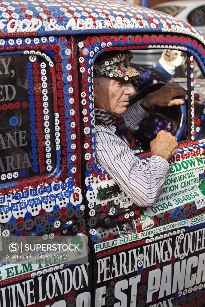 England, London, Greenwich. A taxi driver in a Pearly Kings and Queens decorated London taxi cab.