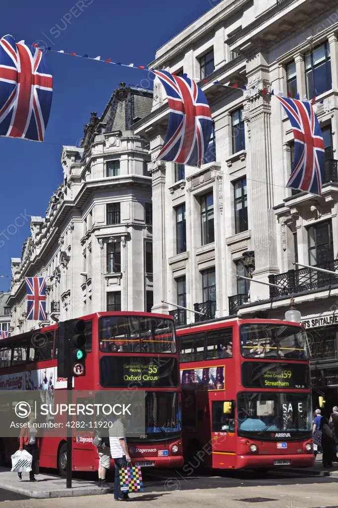 England, London, Regent Street. Red double decker buses waiting at traffic lights under red, white and blue bunting strung across Regent Street to celebrate the Royal Wedding between Prince William and Catherine Middleton.