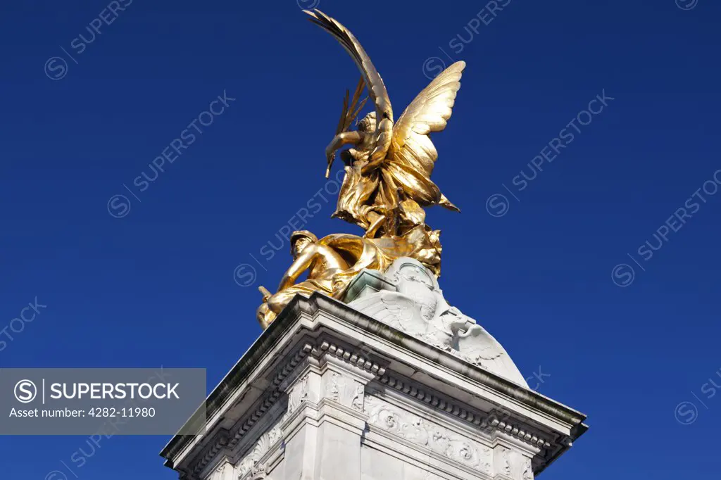 England, London, Buckingham Palace. Gilded bronze figure of Victory by Sir Thomas Brock on top of the Queen Victoria Memorial outside Buckingham Palace.