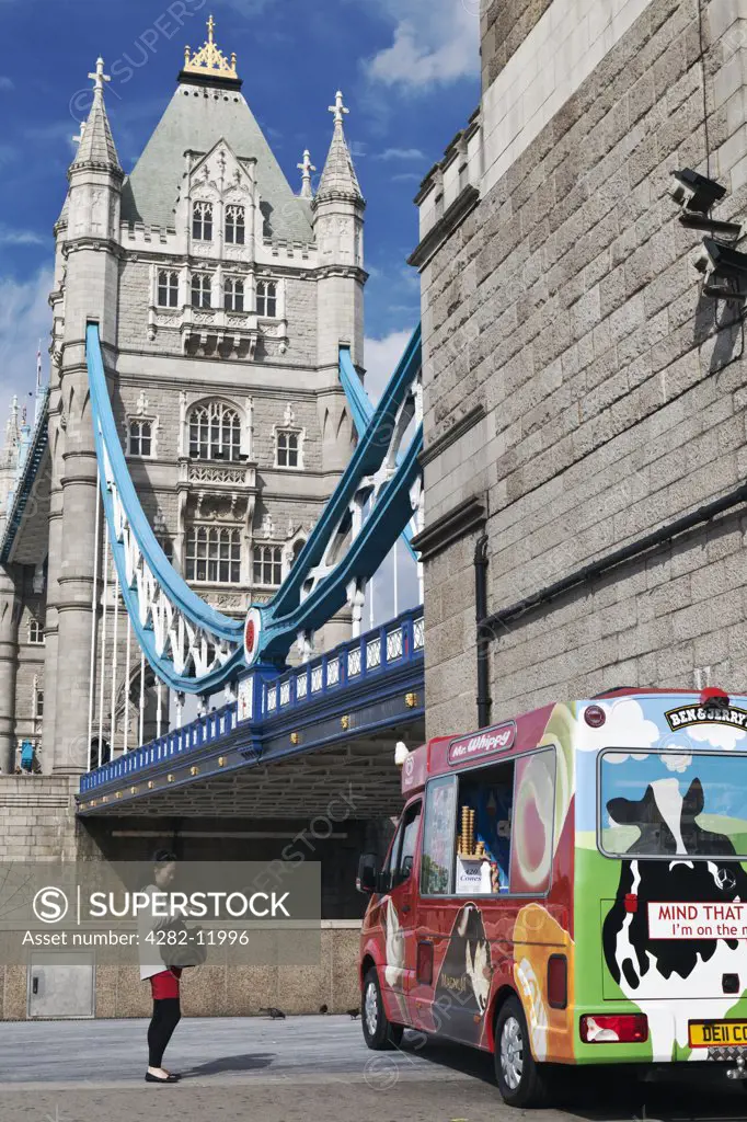 England, London, Tower Bridge. A woman approaching an ice cream van parked next to Tower Bridge.