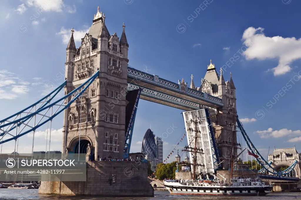 England, London, Tower Bridge. The bascules of Tower Bridge are raised to allow a tall ship to travel along the River Thames.