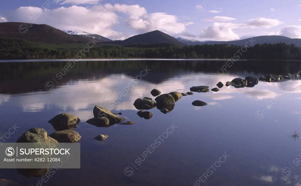 Scotland, Highland, Loch Morlich. The Cairngorm mountain range reflected in still waters of Loch Morlich.