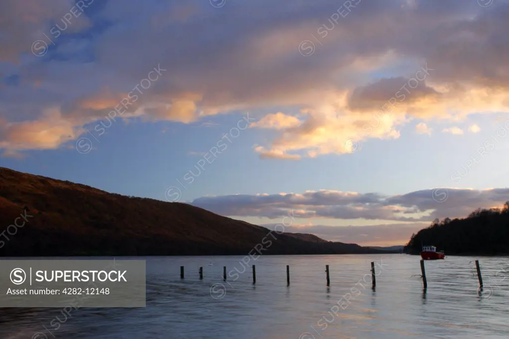 England, Cumbria, Coniston. Afternoon light illuminates the calm waters of Coniston Water on the Cumbria Way.