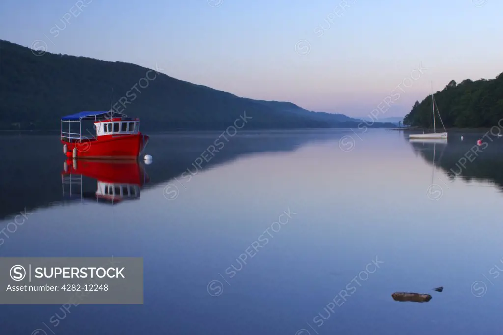 England, Cumbria, Coniston. Dawn looking across the still waters of Coniston Water within the Lake District National Park.